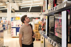 male-shopper-examining-tv-shelf